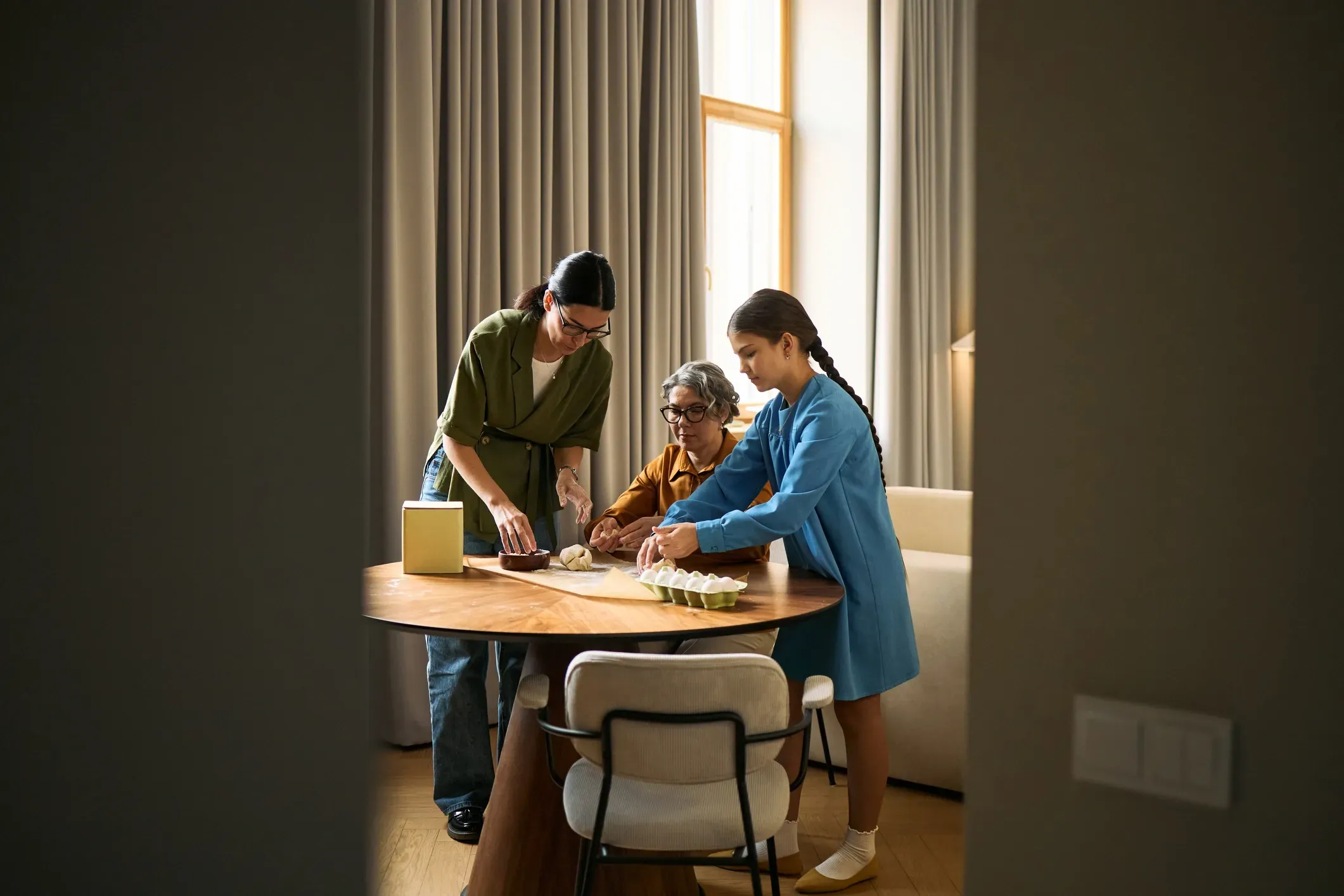 A family cooking together around the kitchen table
